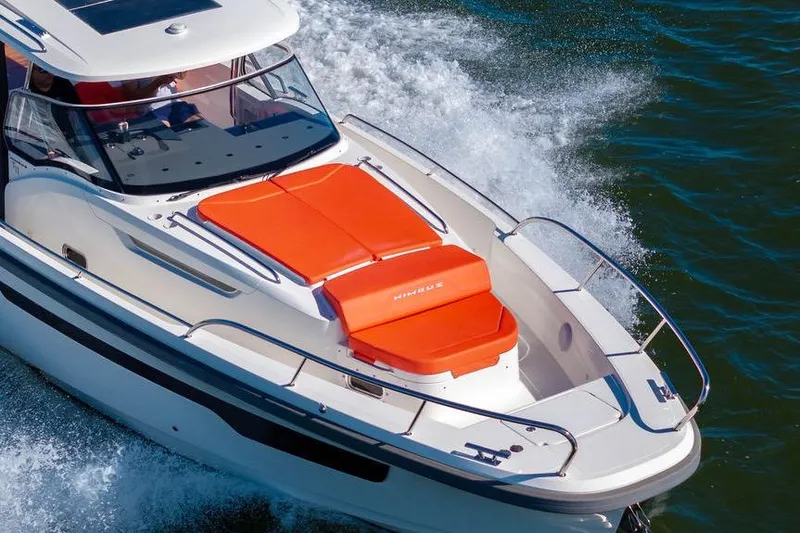  Yacht Photos Pics 2023 Nimbus Tender 11 boat cruising on water with vibrant orange seating.
