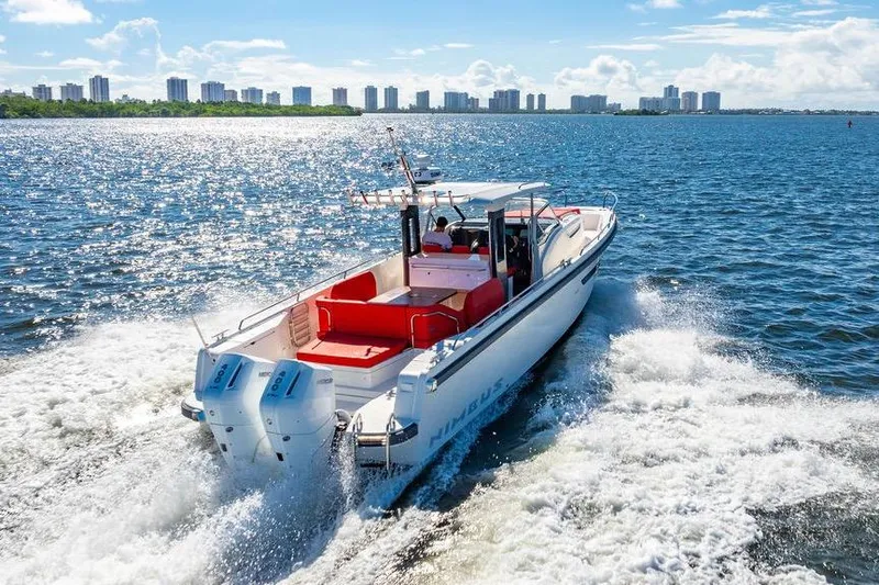  Yacht Photos Pics 2023 Nimbus Tender 11 cruising on a sunny day with city skyline in background.
