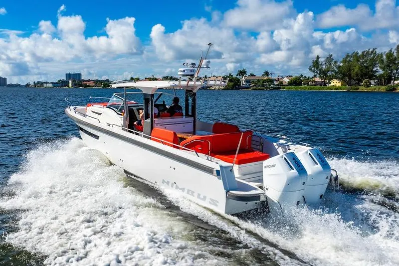  Yacht Photos Pics 2023 Nimbus Tender 11 cruising on a sunny day, featuring sleek design and vibrant seating.