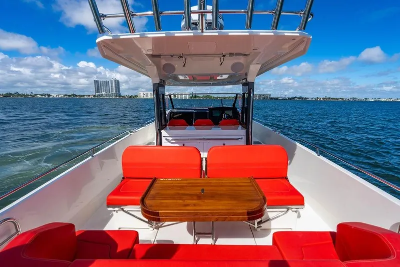 Yacht Photos Pics 2023 Nimbus Tender 11 boat with red seating, wooden table, and ocean view.