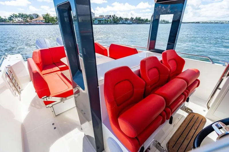  Yacht Photos Pics 2023 Nimbus Tender 11 boat interior with vibrant red seating and scenic water view.