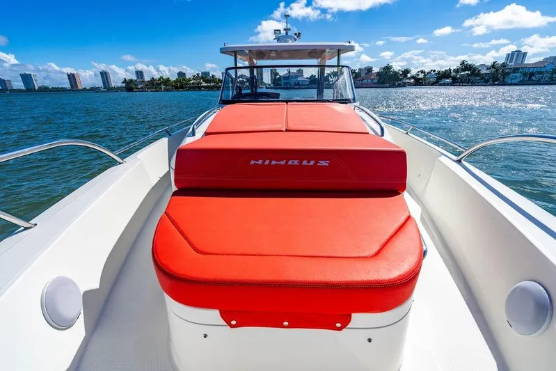  Yacht Photos Pics 2023 Nimbus Tender 11 boat with red seating, cruising on a sunny day.