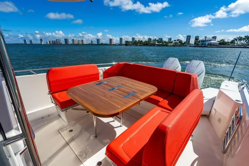  Yacht Photos Pics Luxury Nimbus Tender 11 boat with red seating, wooden table, and scenic waterfront view.