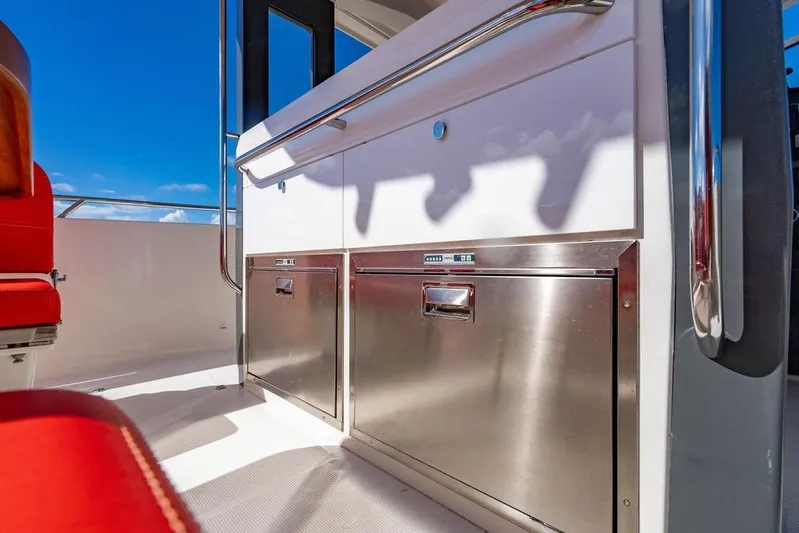  Yacht Photos Pics 2023 Nimbus Tender 11 interior with stainless steel storage and red seating under blue sky.