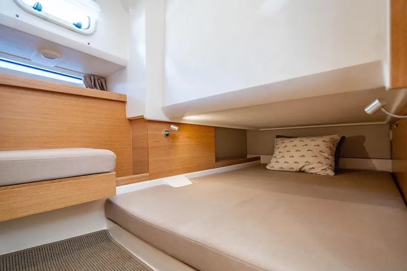  Yacht Photos Pics 2023 Nimbus Tender 11 cabin interior with cozy bed and wooden accents.