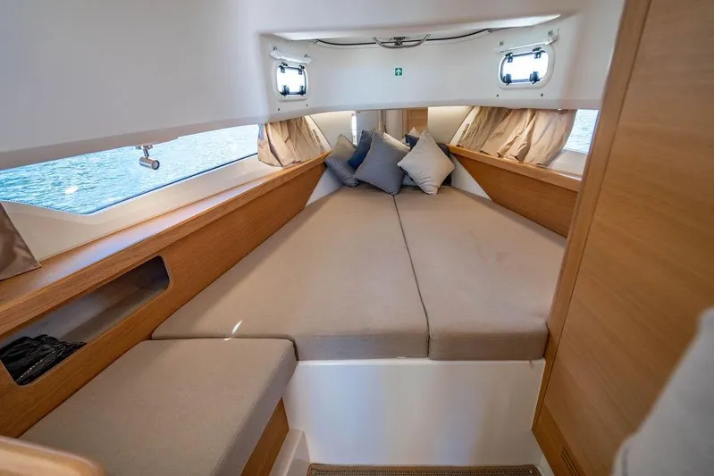  Yacht Photos Pics Cozy cabin interior of 2023 Nimbus Tender 11 with cushions and wooden accents.