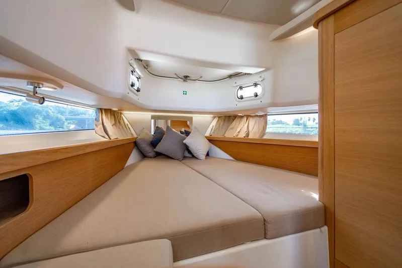  Yacht Photos Pics Luxurious interior cabin of 2023 Nimbus Tender 11 with cozy bedding and wooden accents.
