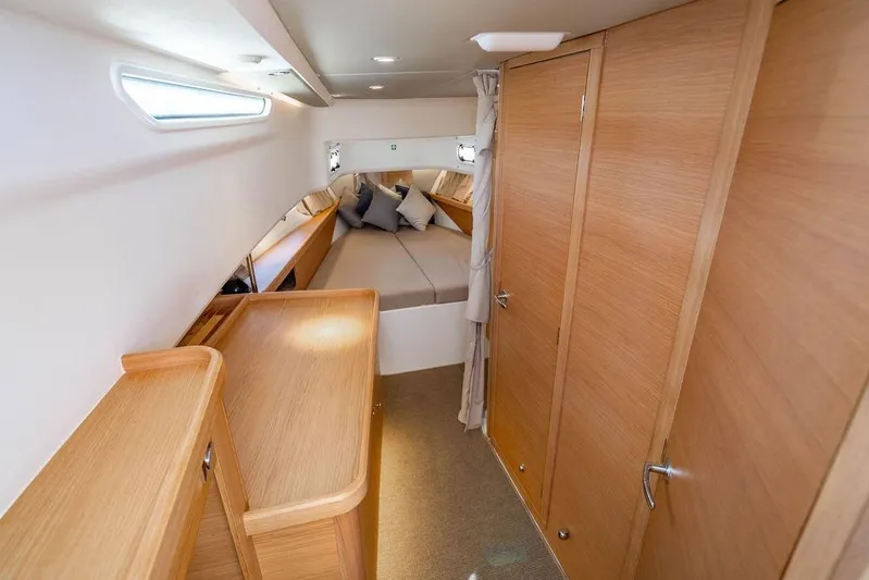  Yacht Photos Pics Luxurious interior cabin of 2023 Nimbus Tender 11 with wooden finishes and cozy bedding.