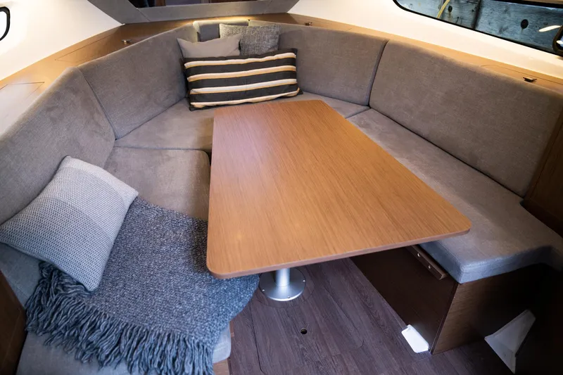  Yacht Photos Pics Cozy interior of 2024 Beneteau Gran Turismo 32 Inboard with plush seating and wooden table.