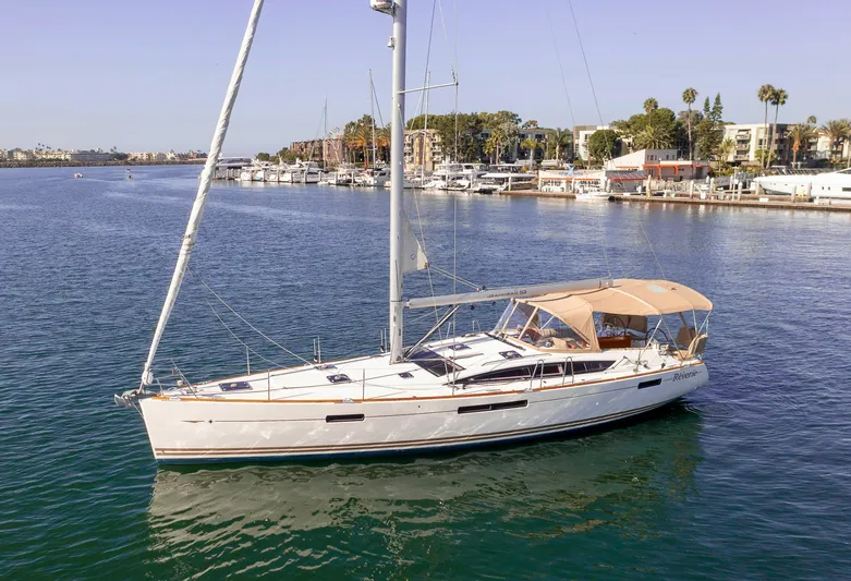 Shenanigans Yacht Photos Pics 2015 Jeanneau 53DS sailboat on calm water near marina.