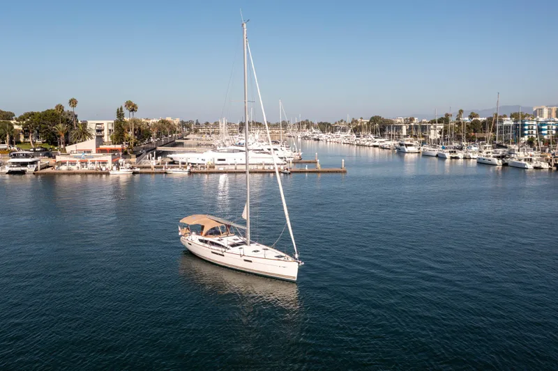 Shenanigans Yacht Photos Pics 2015 Jeanneau 53DS sailboat in a marina, surrounded by other boats.