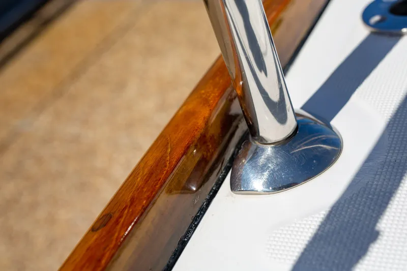 Shenanigans Yacht Photos Pics Close-up of Jeanneau 53DS 2015 yacht's polished metal and wood deck detail.
