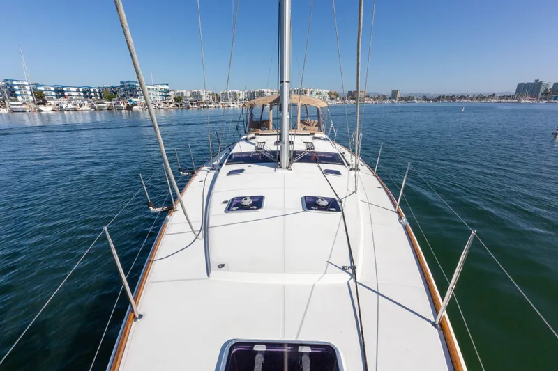 Shenanigans Yacht Photos Pics 2015 Jeanneau 53DS sailboat on calm water, clear sky, marina in background.