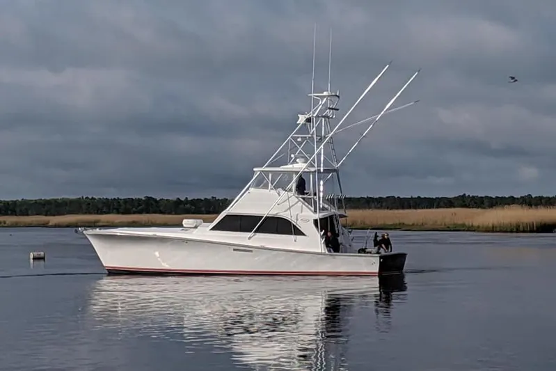  Yacht Photos Pics Ocean Yachts 55 Super Sport 1982 model on calm water under cloudy sky.