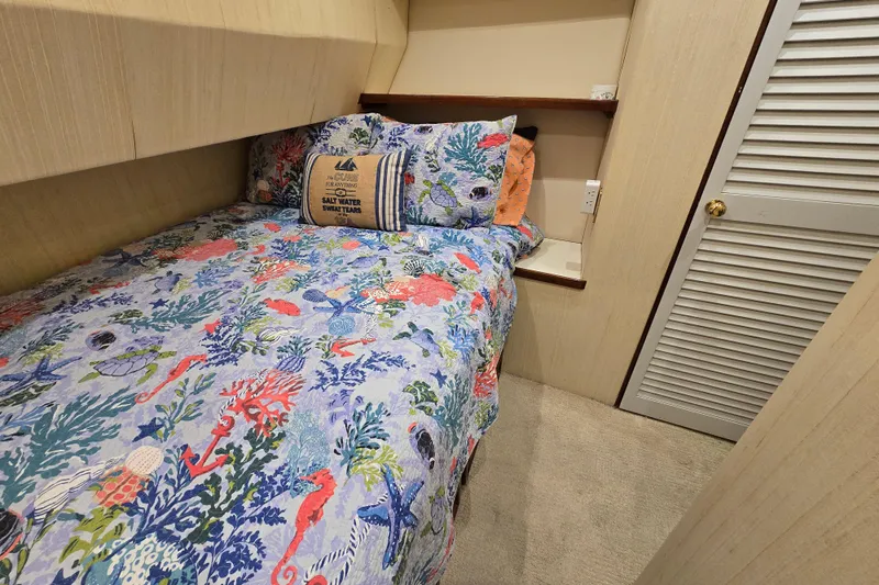  Yacht Photos Pics Cozy cabin bedroom in 1982 Ocean Yachts 55 Super Sport, featuring nautical-themed bedding.