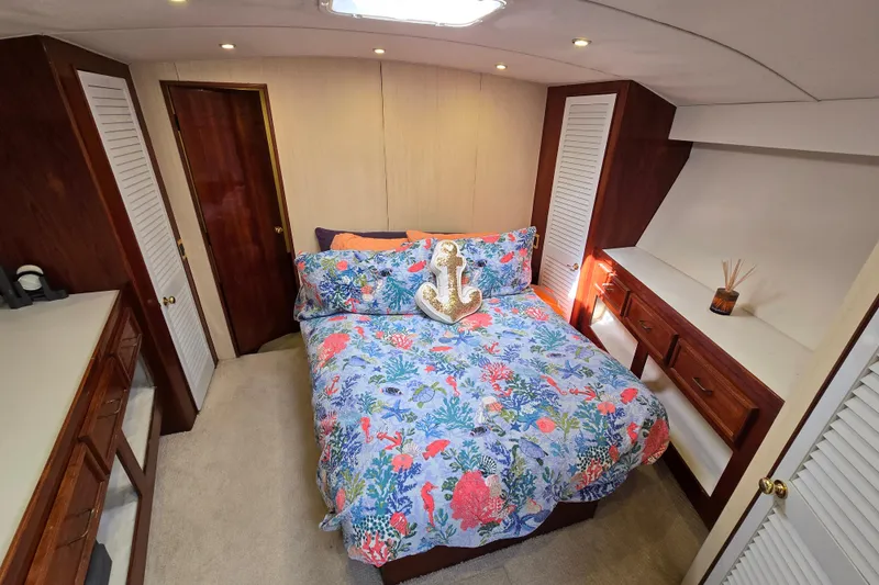  Yacht Photos Pics Luxurious bedroom in 1982 Ocean Yachts 55 Super Sport, featuring vibrant bedding and elegant wood finishes.