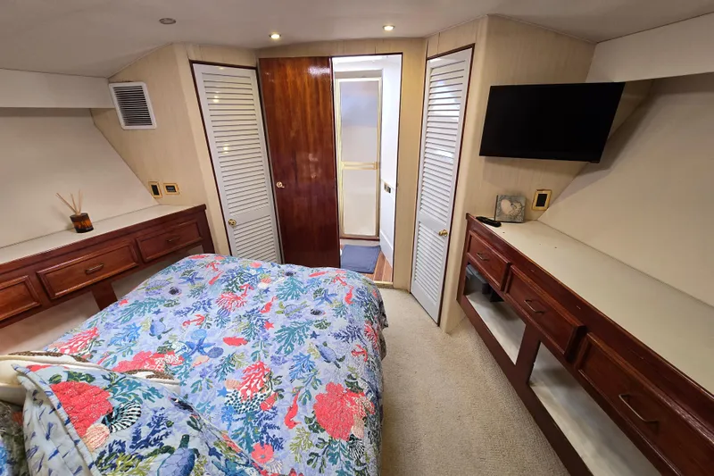  Yacht Photos Pics Luxurious bedroom in 1982 Ocean Yachts 55 Super Sport, featuring floral bedding and modern amenities.
