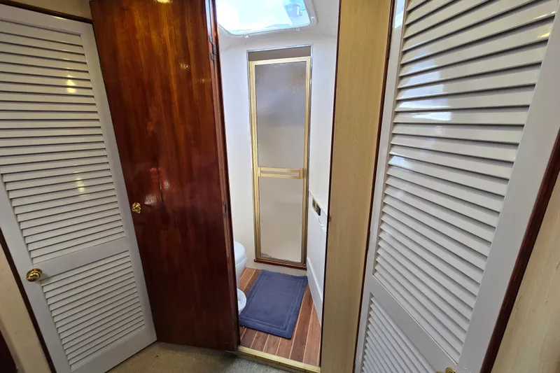  Yacht Photos Pics Interior of 1982 Ocean Yachts 55 Super Sport, featuring wooden doors and a compact bathroom.