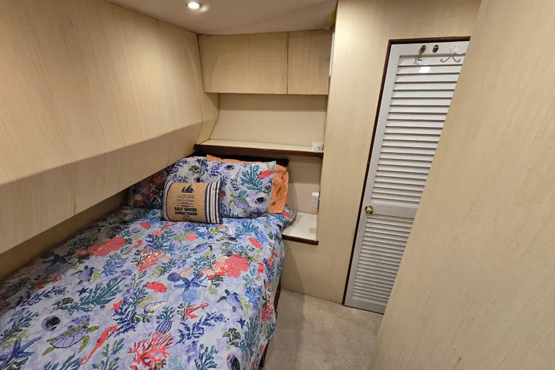  Yacht Photos Pics Cozy bedroom in 1982 Ocean Yachts 55 Super Sport, featuring nautical-themed bedding.