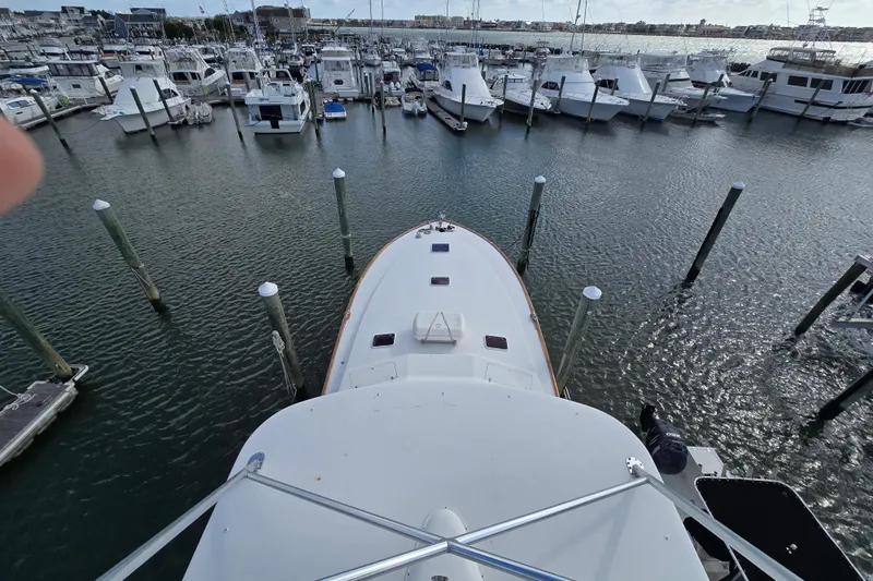  Yacht Photos Pics Ocean Yachts 55 Super Sport 1982 docked in a marina, surrounded by other boats.