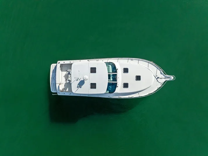 Blue Pearl Yacht Photos Pics Aerial view of 2004 Tiara Yachts 4200 Open on green water.