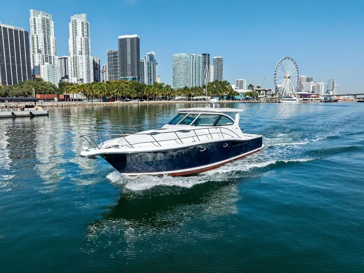 Blue Pearl Yacht Photos Pics 2004 Tiara Yachts 4200 Open cruising near city skyline and Ferris wheel.