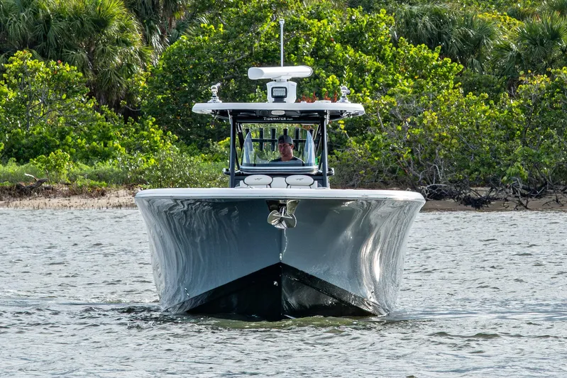 Going Propless Yacht Photos Pics 2020 Tidewater 320 CC Adventure boat cruising near lush shoreline.