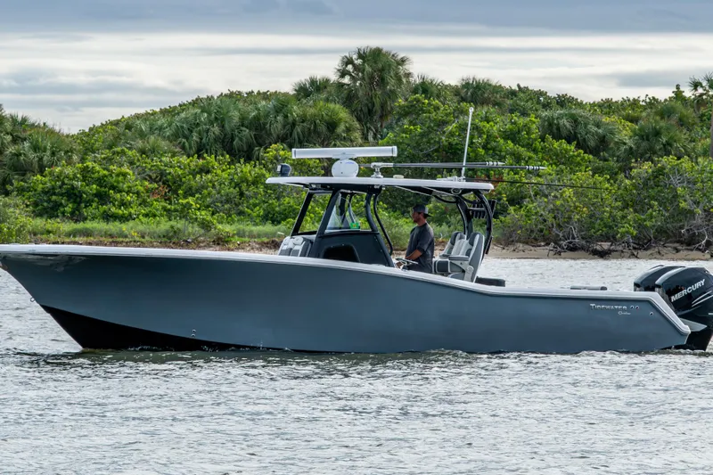 Going Propless Yacht Photos Pics 2020 Tidewater 320 CC Adventure boat cruising near lush green shoreline.