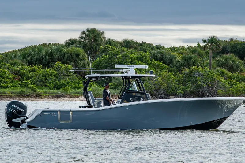 Going Propless Yacht Photos Pics 2020 Tidewater 320 CC Adventure boat cruising near lush green shoreline.