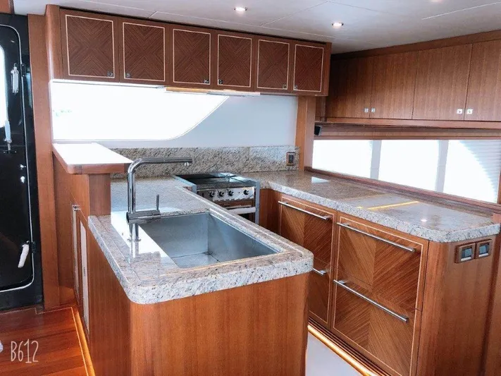  Yacht Photos Pics Luxurious kitchen interior of 2026 Selene 60 Explorer yacht with granite countertops and wooden cabinetry.