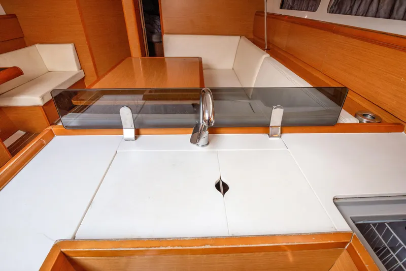  Yacht Photos Pics Interior of 2013 Jeanneau Sun Odyssey 439 yacht, featuring a modern kitchen and seating area.