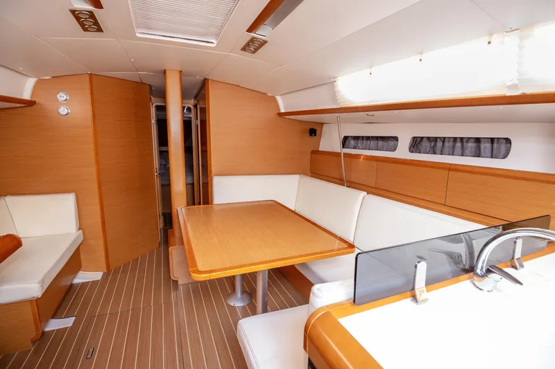  Yacht Photos Pics Interior of 2013 Jeanneau Sun Odyssey 439 yacht with modern wood finish and seating area.