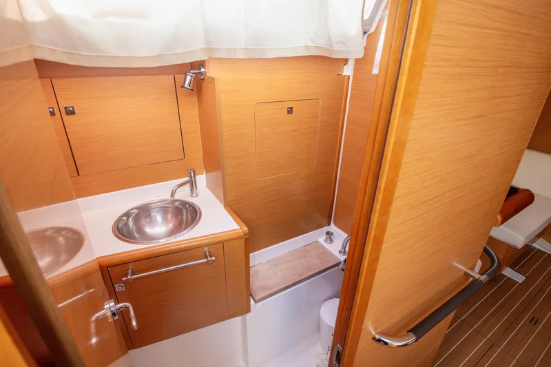 Yacht Photos Pics 2013 Jeanneau Sun Odyssey 439 bathroom with wooden cabinetry and stainless steel sink.
