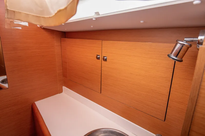  Yacht Photos Pics Interior of 2013 Jeanneau Sun Odyssey 439 yacht bathroom with wooden cabinetry.