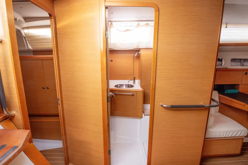  Yacht Photos Pics Interior of 2013 Jeanneau Sun Odyssey 439 yacht, featuring a compact bathroom and wooden cabinetry.