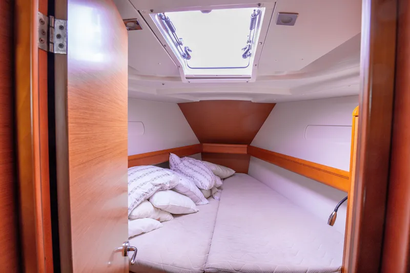  Yacht Photos Pics Cozy cabin interior of 2013 Jeanneau Sun Odyssey 439 sailboat with skylight and bedding.
