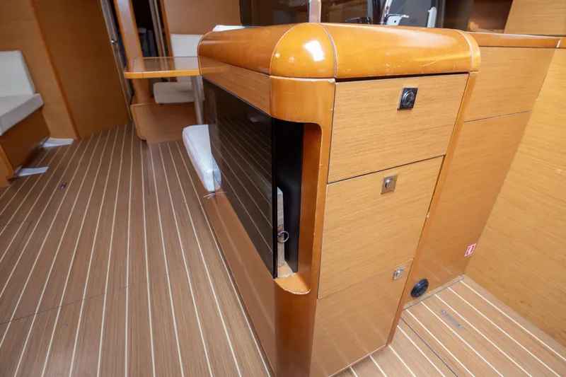  Yacht Photos Pics Interior of 2013 Jeanneau Sun Odyssey 439 yacht with wooden cabinetry and striped flooring.