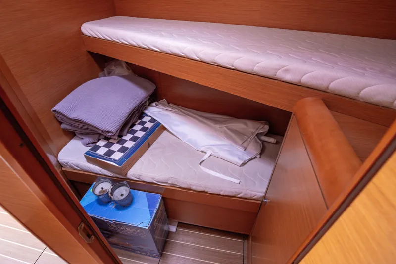  Yacht Photos Pics Cozy cabin interior of 2013 Jeanneau Sun Odyssey 439 sailboat with storage and bedding.