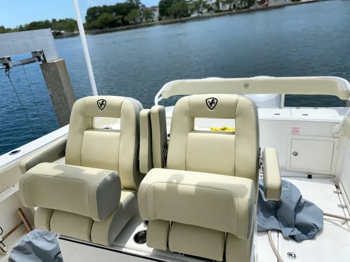 Gone Cucu Yacht Photos Pics Century 3200 Center Console 2020 boat with beige seating, docked by calm waters.