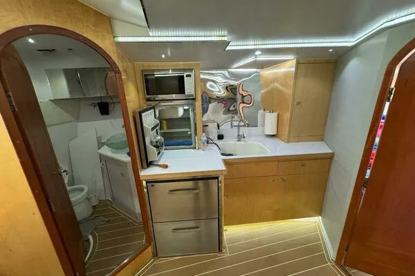 Joujou 2 Yacht Photos Pics 2002 Luhrs 38 Open yacht interior with kitchenette, featuring modern appliances and wood cabinetry.