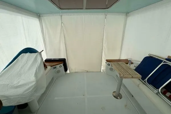 Joujou 2 Yacht Photos Pics 2002 Luhrs 38 Open boat interior with seating and table, enclosed by white curtains.