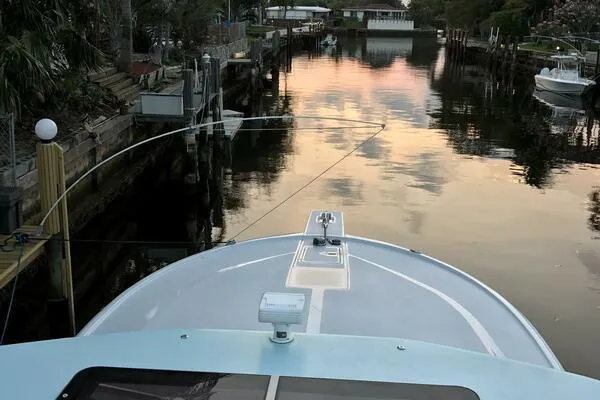 Joujou 2 Yacht Photos Pics Bow view of 2002 Luhrs 38 Open boat on a tranquil waterway at sunset.