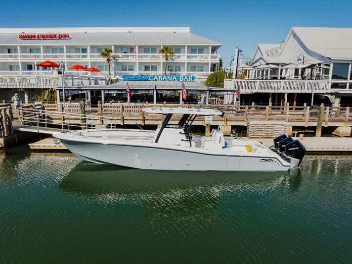  Yacht Photos Pics 2025 Invincible 36 Open Fisherman boat docked near waterfront bar.