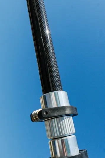  Yacht Photos Pics Close-up of a fishing rod component against a clear blue sky.