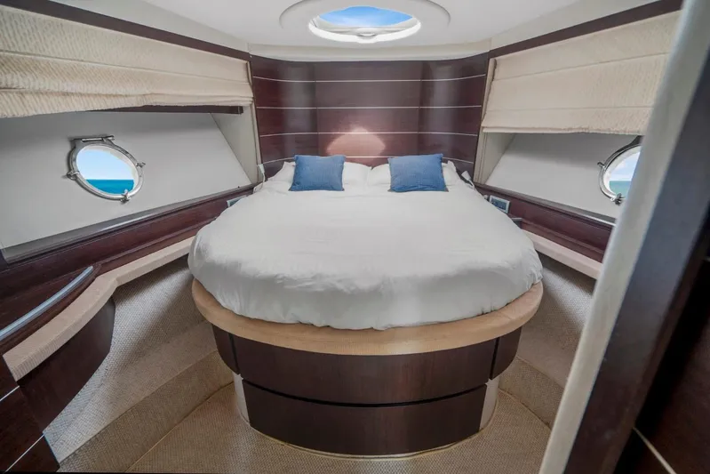 Yacht Photos Pics Luxurious bedroom interior of 2007 Azimut 68S yacht with round bed and porthole windows.