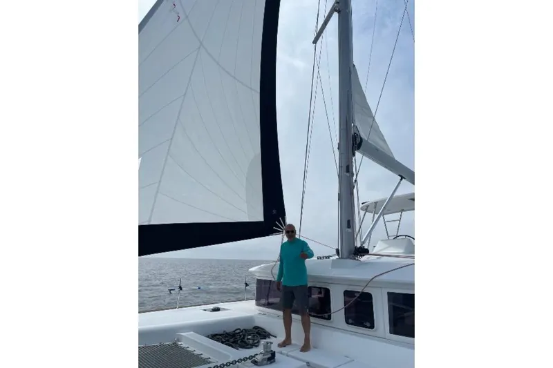 Whatif Yacht Photos Pics Man sailing on a 2013 Lagoon 450 catamaran with large sails.