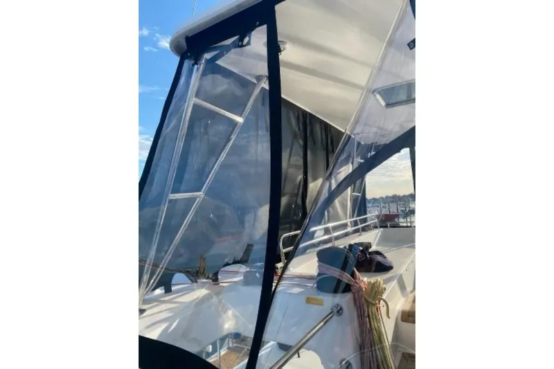 Whatif Yacht Photos Pics 2013 Lagoon 450 catamaran with clear enclosure, docked under blue sky.