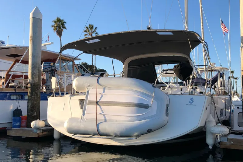 Shades Of Grey Yacht Photos Pics 2016 Beneteau Oceanis 473 yacht docked with inflatable boat, palm trees in background.