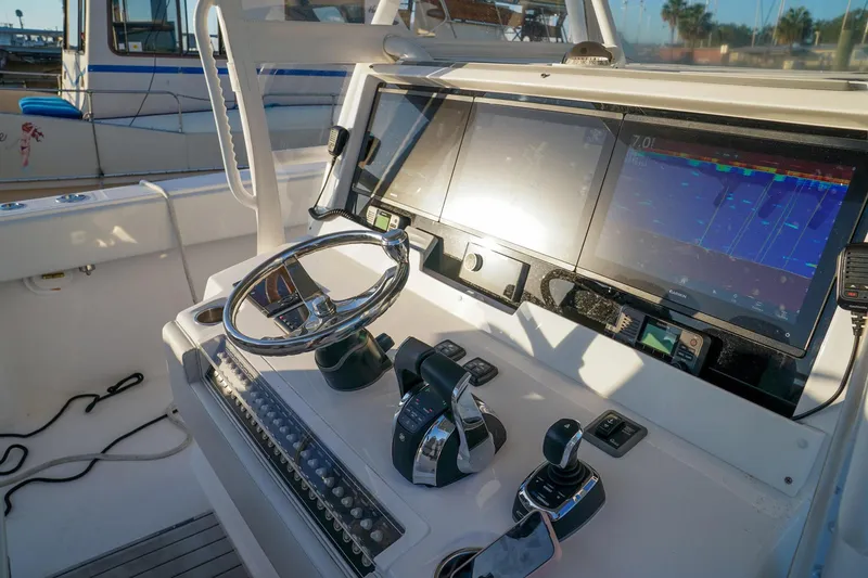 Another One Yacht Photos Pics Control panel of 2019 Invincible 40 Catamaran with steering wheel and navigation screens.