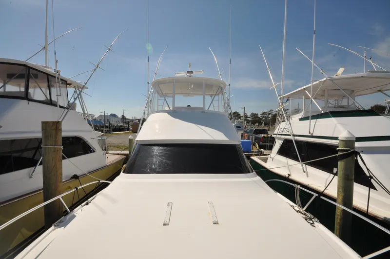  Yacht Photos Pics 2019 Viking 44 Convertible yacht docked among other boats under clear skies.